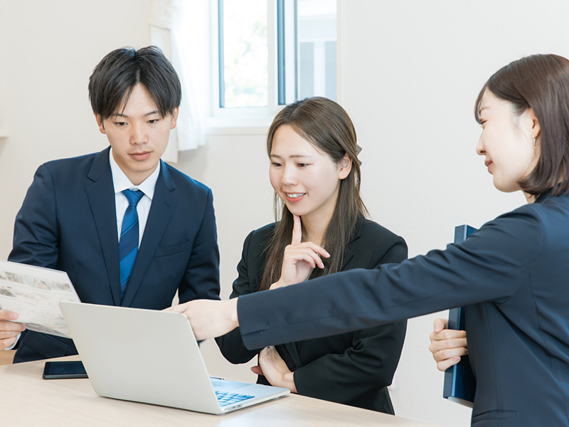 データを見ながら打ち合わせをするビジネスパーソン